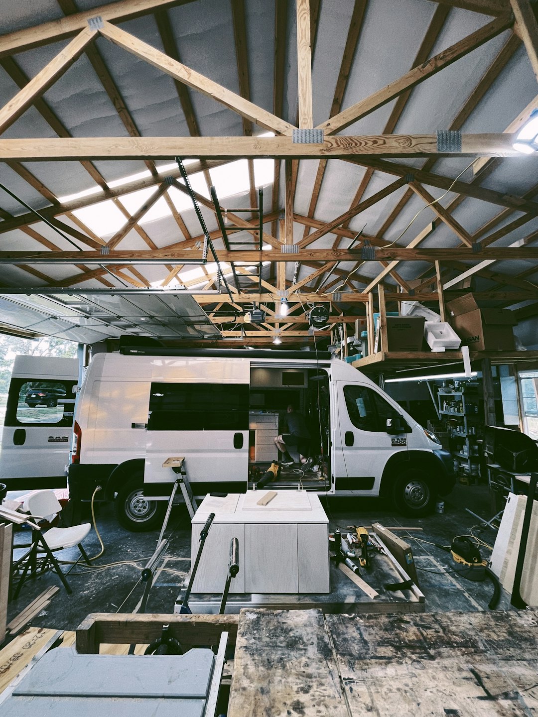 Person baut maßgefertigte Schränke in einem weißen RAM ProMaster Van.